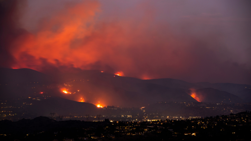 A nighttime wildfire tears through the hills of California