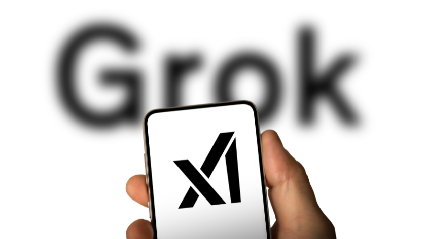 Elon Musk's AI startup and OpenAI rival xAI's logo displayed on a smartphone in front of the word Grok, the name of its foundation 