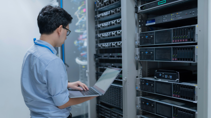 Computer engineer is setting up network in server room,Systems Maintenance Technician,Male engineer working in server room at modern data center