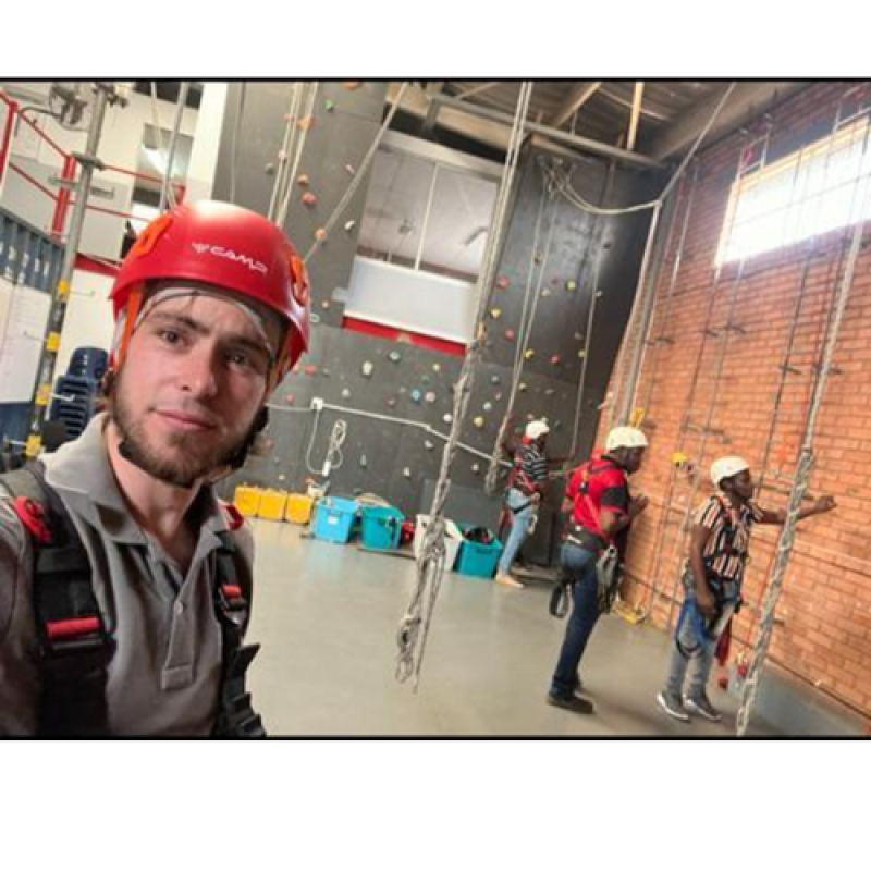 Ruan in a hardhat, infront of trainee's looking at ropes